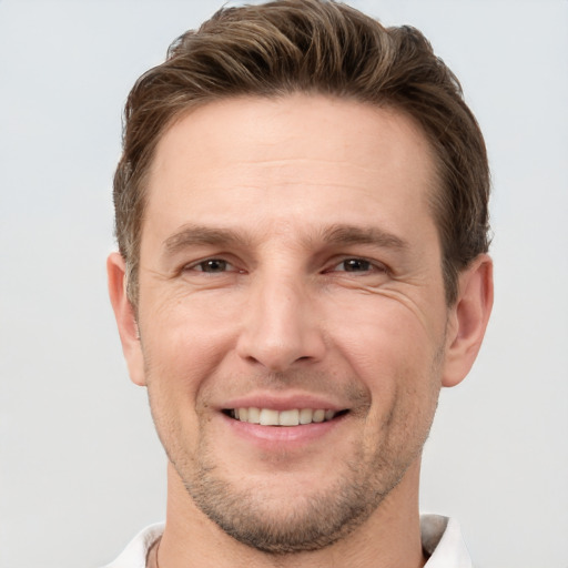 Joyful white adult male with short  brown hair and grey eyes