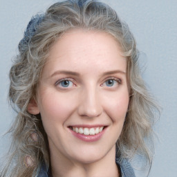 Joyful white young-adult female with long  brown hair and blue eyes