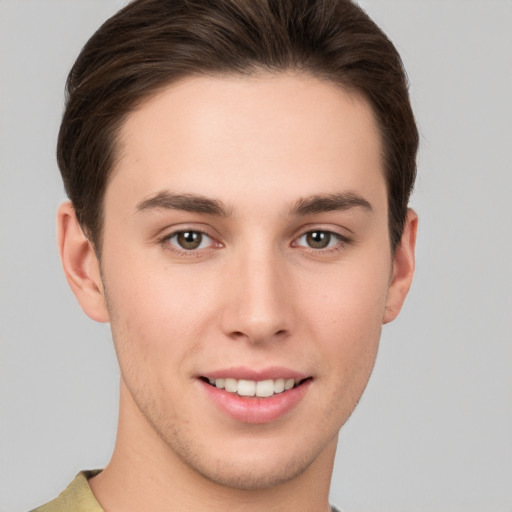 Joyful white young-adult male with short  brown hair and grey eyes