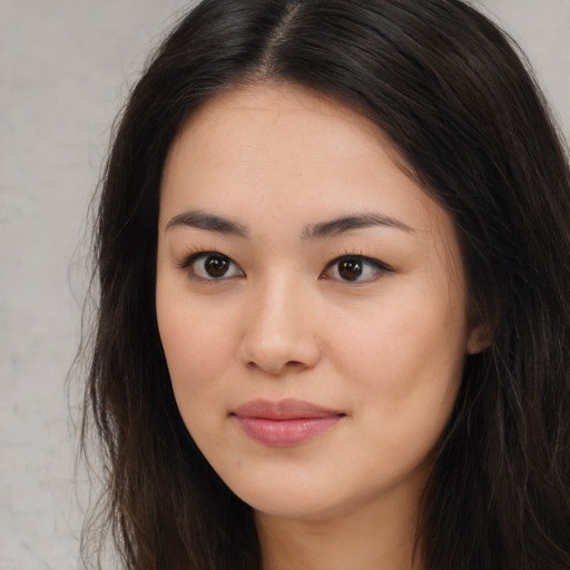 Joyful asian young-adult female with long  brown hair and brown eyes