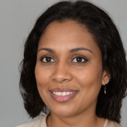 Joyful black young-adult female with medium  brown hair and brown eyes