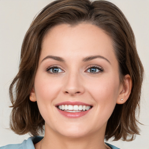 Joyful white young-adult female with medium  brown hair and blue eyes