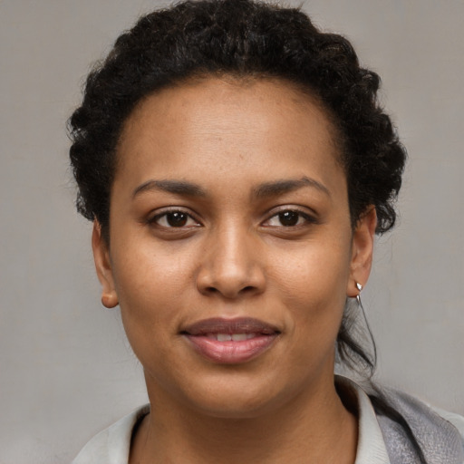 Joyful black young-adult female with short  brown hair and brown eyes