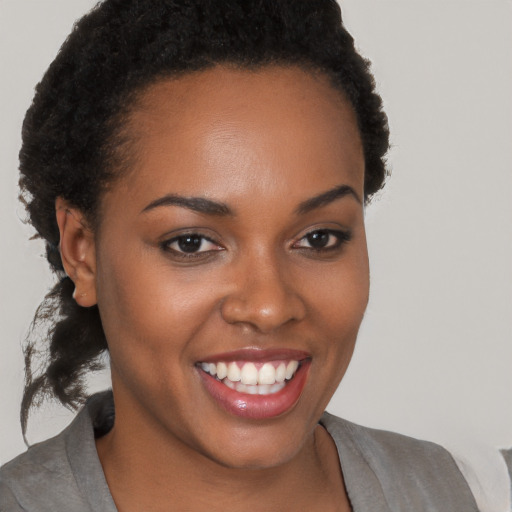 Joyful black young-adult female with short  brown hair and brown eyes