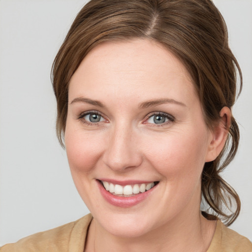 Joyful white young-adult female with medium  brown hair and blue eyes