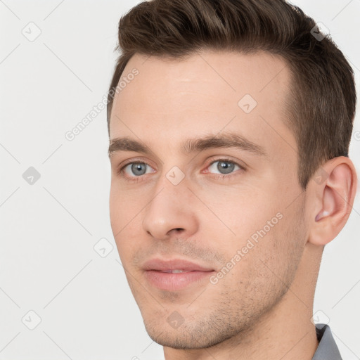 Joyful white young-adult male with short  brown hair and grey eyes