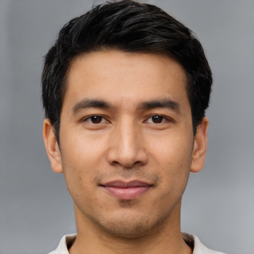 Joyful latino young-adult male with short  black hair and brown eyes