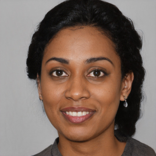Joyful black young-adult female with medium  black hair and brown eyes