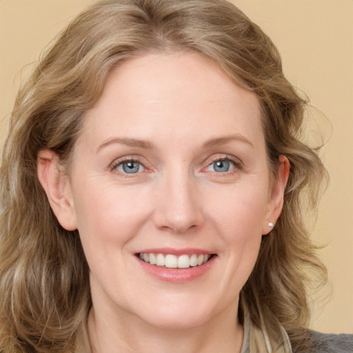 Joyful white young-adult female with long  brown hair and blue eyes