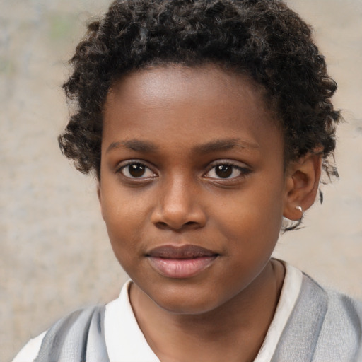 Joyful black child male with short  brown hair and brown eyes