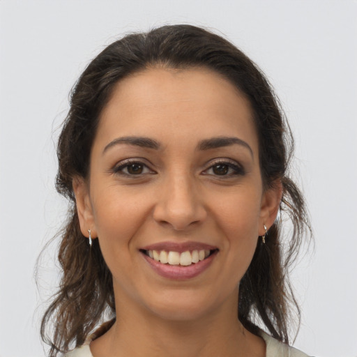 Joyful latino young-adult female with medium  brown hair and brown eyes