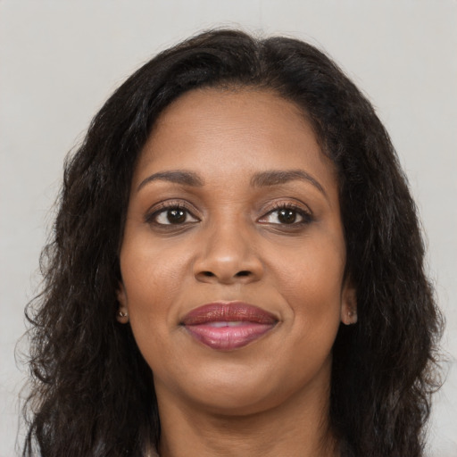 Joyful black young-adult female with long  brown hair and brown eyes