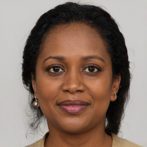 Joyful black adult female with long  brown hair and brown eyes