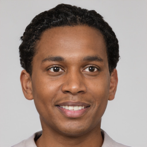 Joyful black young-adult male with short  black hair and brown eyes