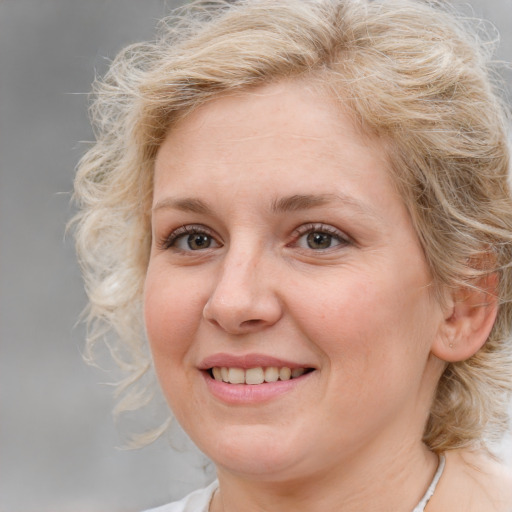 Joyful white young-adult female with medium  brown hair and blue eyes