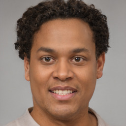 Joyful latino young-adult male with short  brown hair and brown eyes