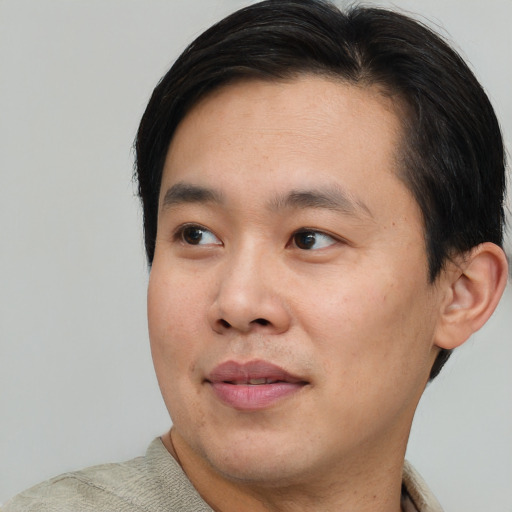 Joyful asian young-adult male with short  black hair and brown eyes