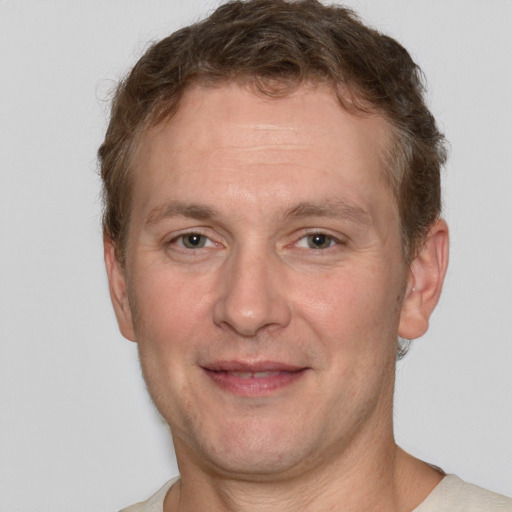 Joyful white adult male with short  brown hair and grey eyes