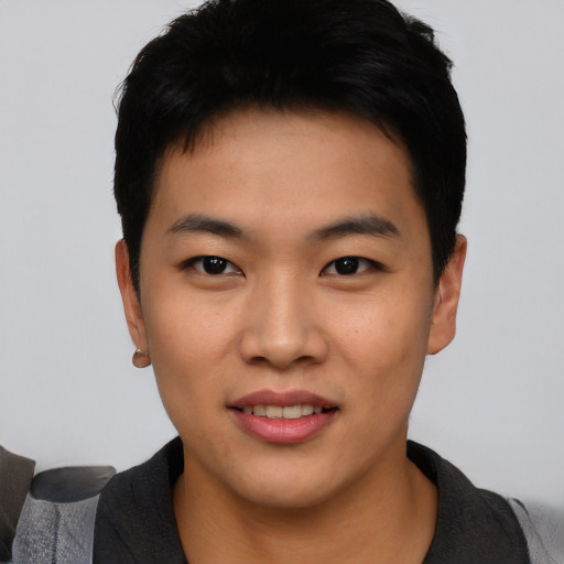 Joyful asian young-adult male with short  black hair and brown eyes