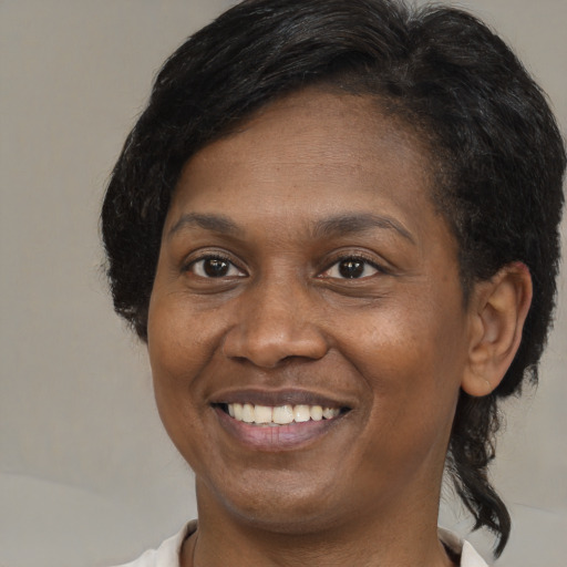 Joyful black adult female with medium  black hair and brown eyes