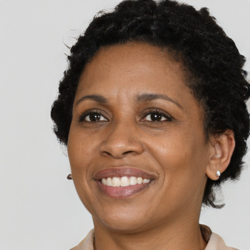 Joyful black adult female with short  black hair and brown eyes