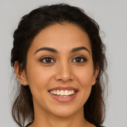 Joyful latino young-adult female with long  brown hair and brown eyes