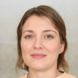 Joyful white young-adult female with medium  brown hair and green eyes