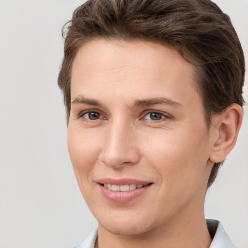 Joyful white young-adult female with short  brown hair and grey eyes