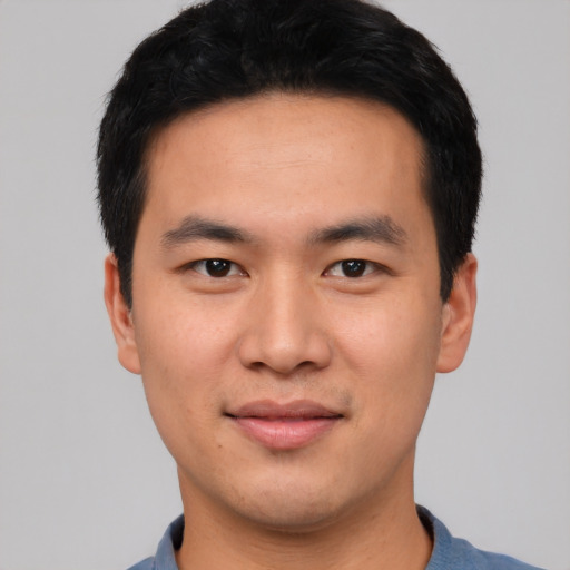Joyful asian young-adult male with short  black hair and brown eyes