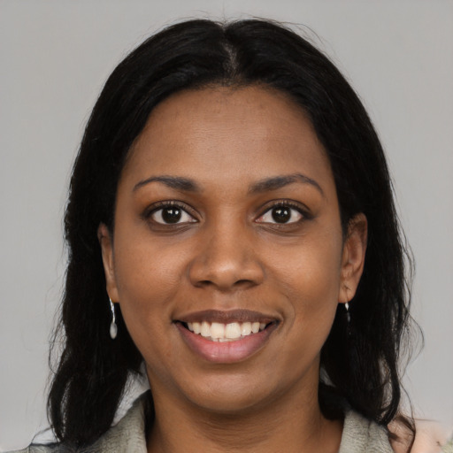 Joyful black young-adult female with long  black hair and brown eyes