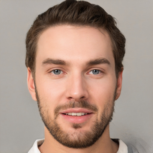 Joyful white young-adult male with short  brown hair and grey eyes