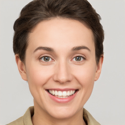 Joyful white young-adult female with short  brown hair and grey eyes