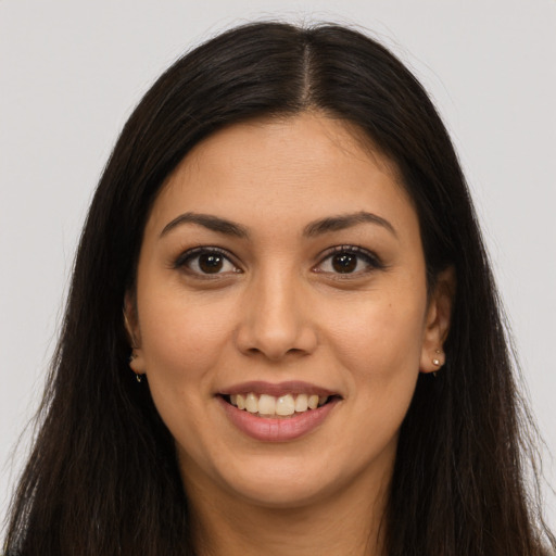 Joyful latino young-adult female with long  brown hair and brown eyes