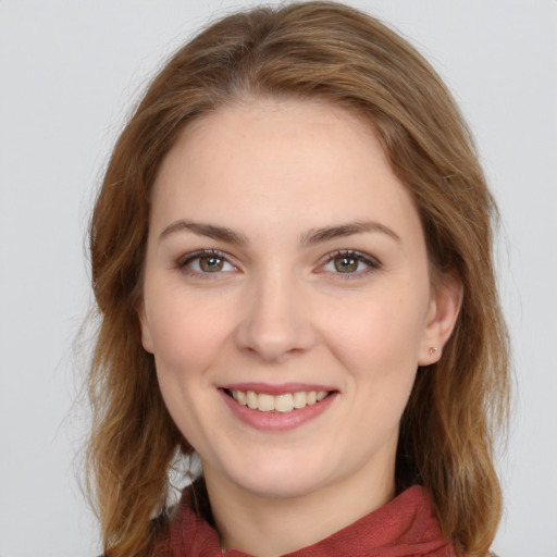 Joyful white young-adult female with medium  brown hair and green eyes