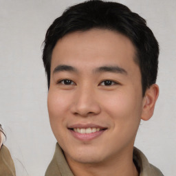 Joyful asian young-adult male with short  brown hair and brown eyes