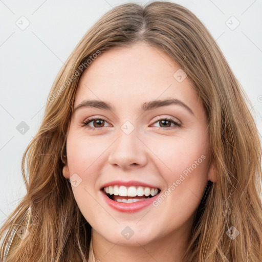 Joyful white young-adult female with long  brown hair and green eyes