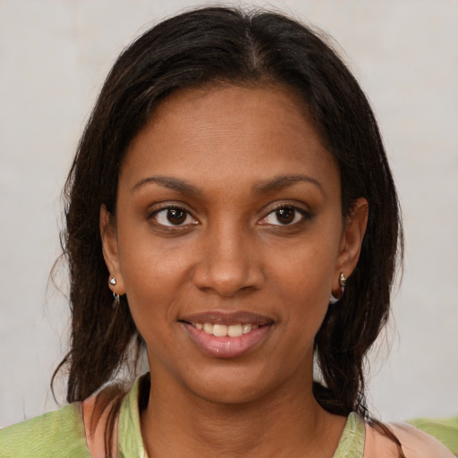 Joyful black young-adult female with medium  brown hair and brown eyes