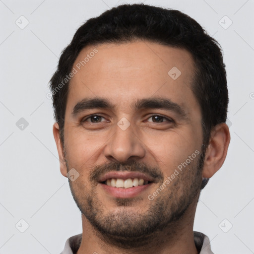 Joyful white young-adult male with short  black hair and brown eyes