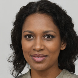 Joyful black adult female with medium  brown hair and brown eyes