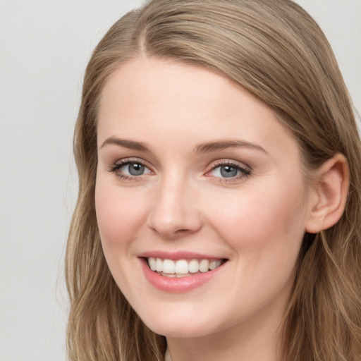 Joyful white young-adult female with long  brown hair and blue eyes