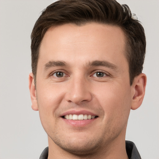 Joyful white young-adult male with short  brown hair and grey eyes