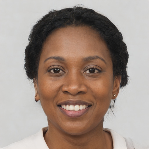 Joyful black adult female with short  black hair and brown eyes