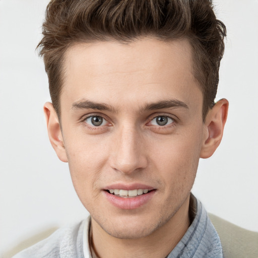 Joyful white young-adult male with short  brown hair and grey eyes