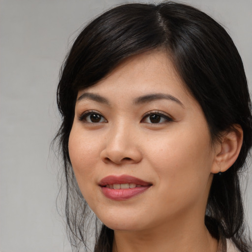 Joyful asian young-adult female with long  black hair and brown eyes