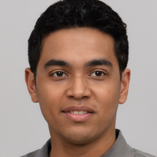 Joyful latino young-adult male with short  black hair and brown eyes