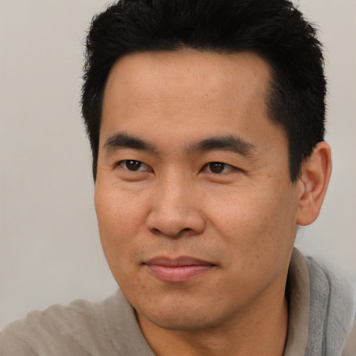 Joyful asian adult male with short  black hair and brown eyes