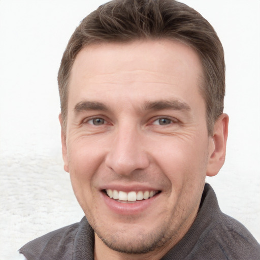 Joyful white young-adult male with short  brown hair and grey eyes