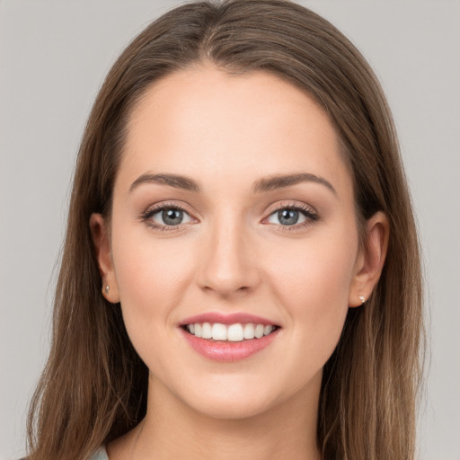 Joyful white young-adult female with long  brown hair and grey eyes