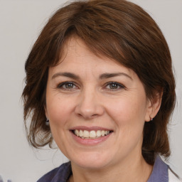 Joyful white adult female with medium  brown hair and brown eyes