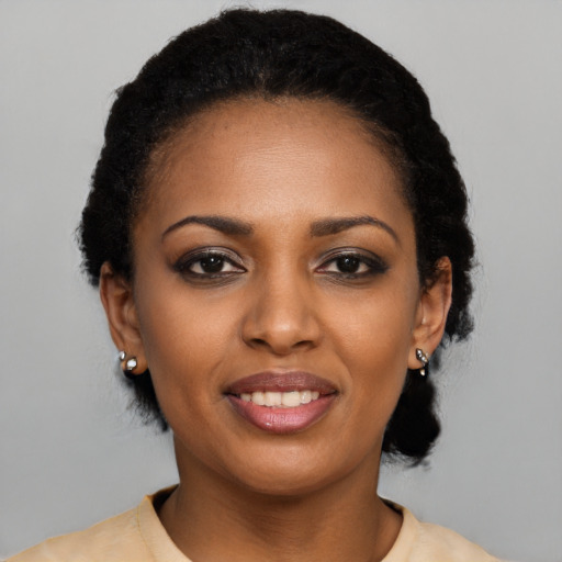 Joyful black young-adult female with short  black hair and brown eyes